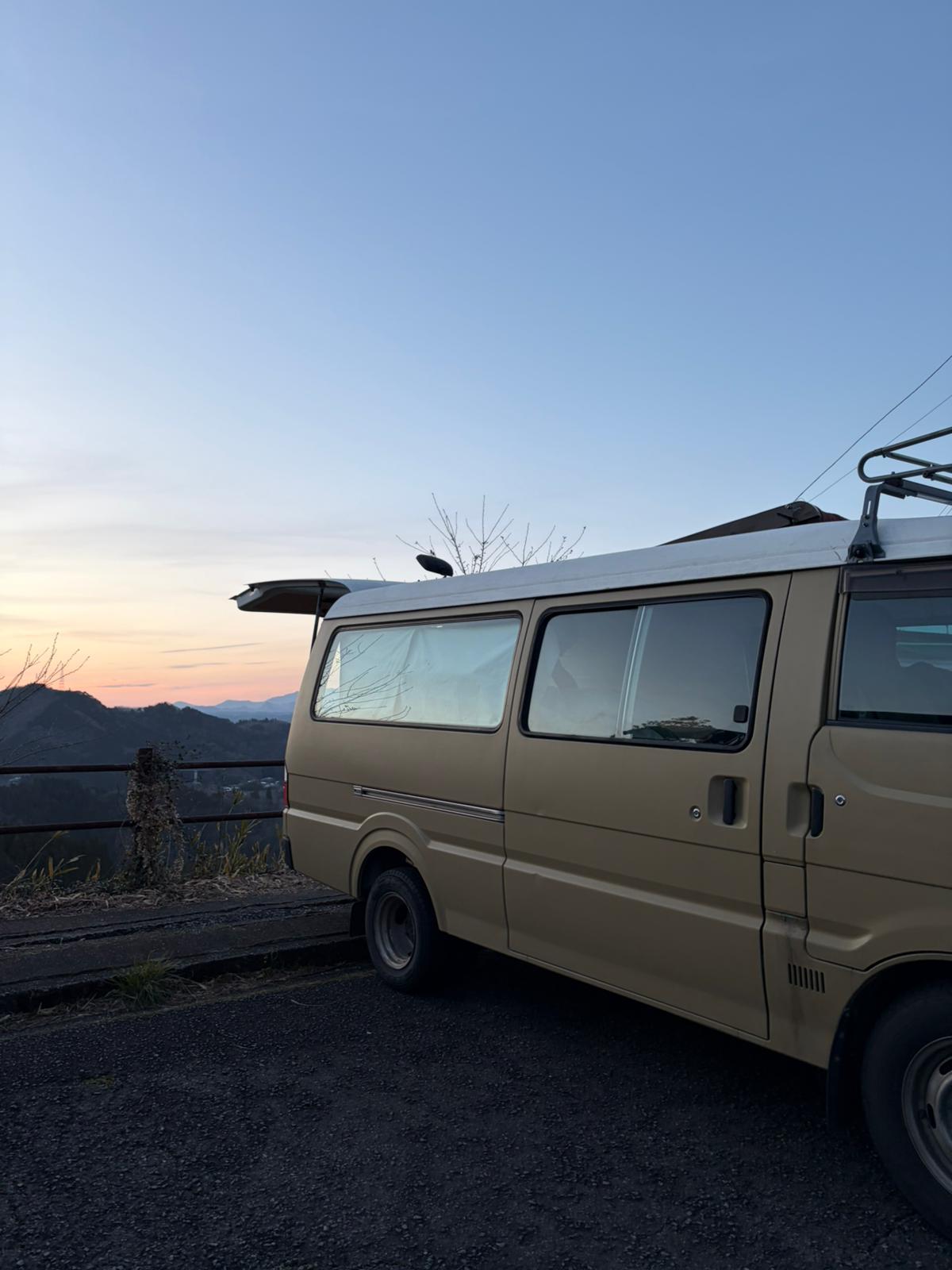 Campervan parked at mountain viewpoint during sunset