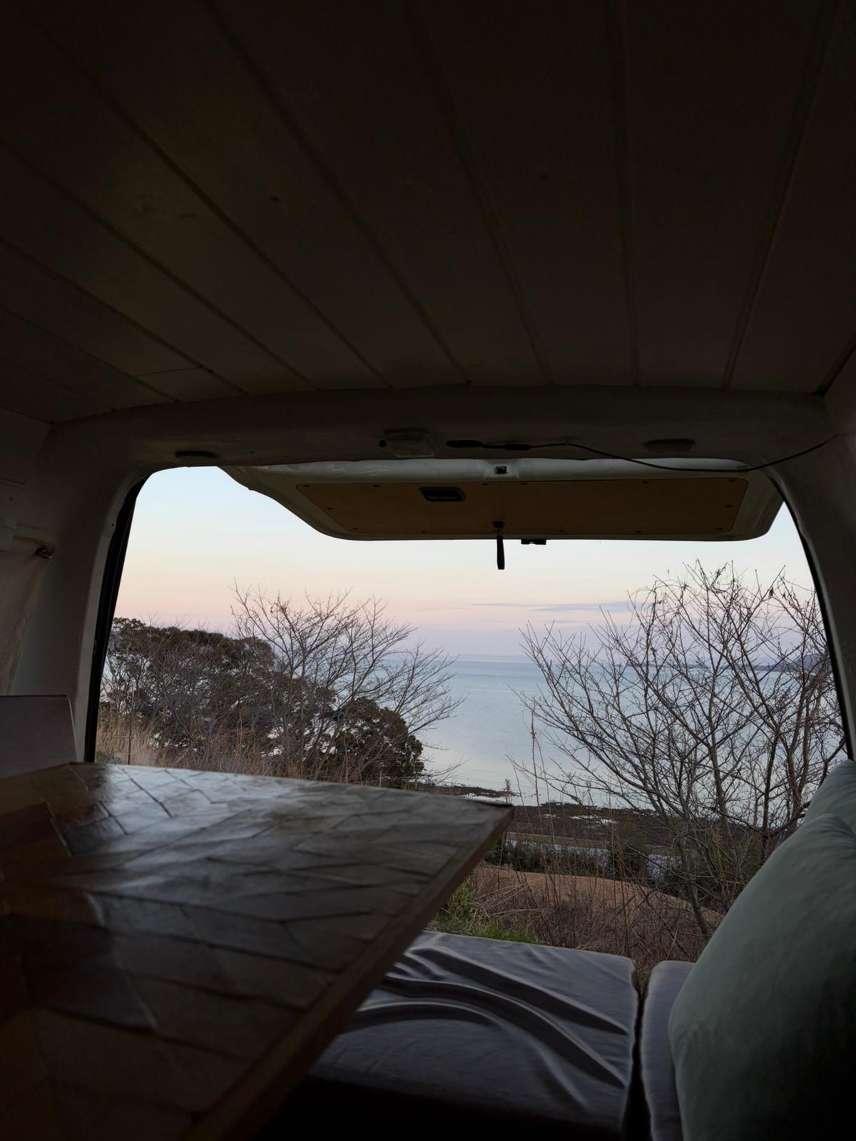 Ocean view from inside the campervan at sunset